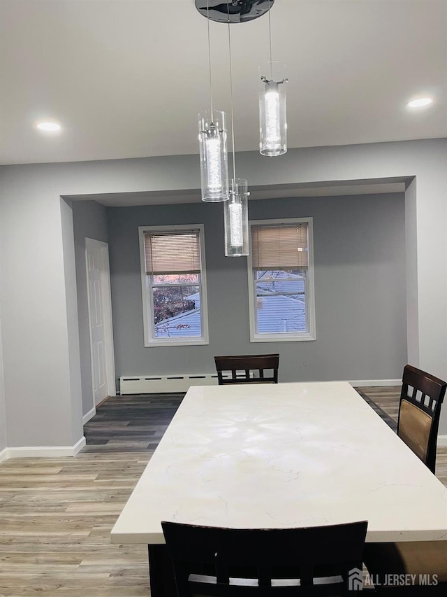 dining room featuring a baseboard heating unit and hardwood / wood-style floors