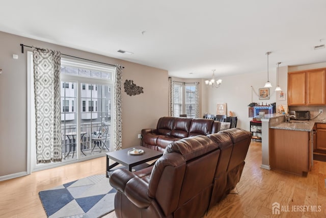 1525 Hudson Cir, Highland Park, NJ 08904 - living area with a chandelier and light wood finished floors