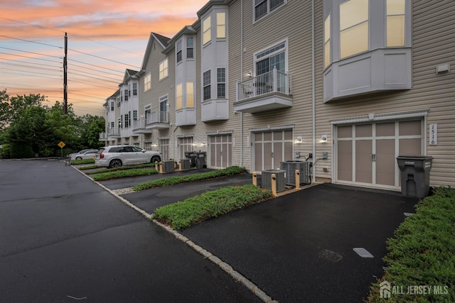 1525 Hudson Cir, Highland Park, NJ 08904 - property at dusk featuring an attached garage, driveway, and central AC