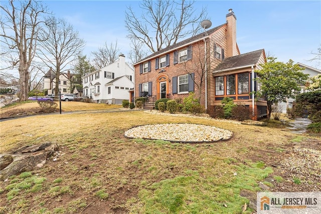 58 Stewart Pl S, Orange Village, NJ 07079 - view of front of house with a chimney, a sunroom, brick siding, a front yard, and a residential view