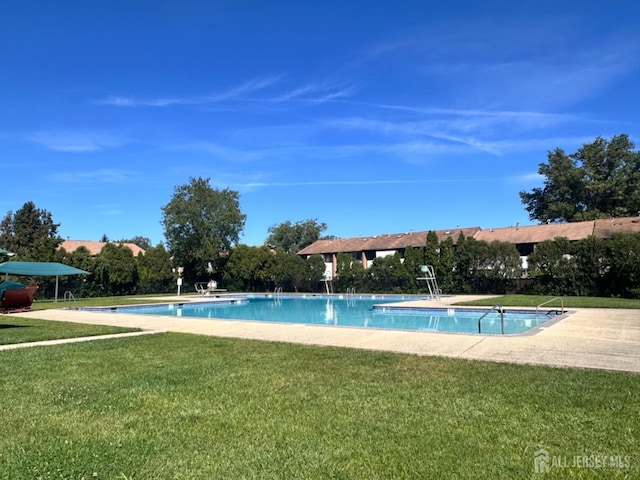 view of swimming pool featuring a yard