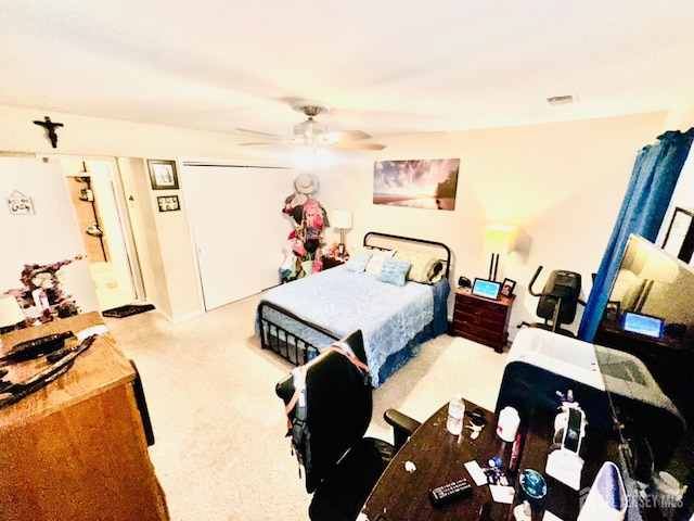 carpeted bedroom with ceiling fan and a closet