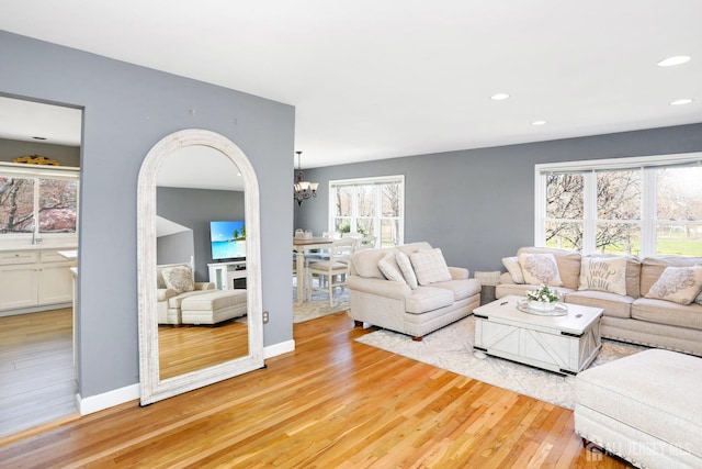 7 Arthurs Ct, Manalapan, NJ 07726 - living room featuring a chandelier, light wood-style flooring, recessed lighting, arched walkways, and baseboards