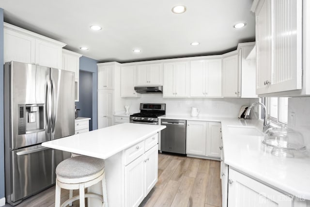 7 Arthurs Ct, Manalapan, NJ 07726 - kitchen featuring appliances with stainless steel finishes, under cabinet range hood, a sink, a center island, and white cabinets