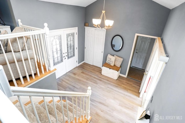 7 Arthurs Ct, Manalapan, NJ 07726 - entrance foyer featuring a chandelier, high vaulted ceiling, wood finished floors, and baseboards