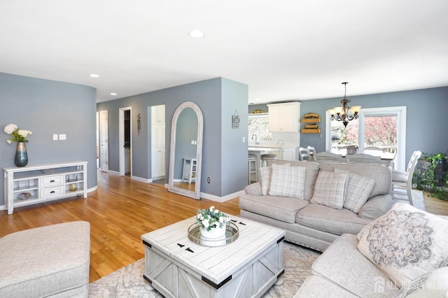 7 Arthurs Ct, Manalapan, NJ 07726 - living area with a chandelier, arched walkways, recessed lighting, light wood-style floors, and baseboards