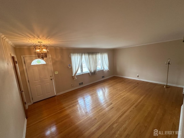 29 Glendale Rd, Colonia, NJ 07067 - foyer entrance with a chandelier, healthy amount of natural light, ornamental molding, wood finished floors, and baseboards