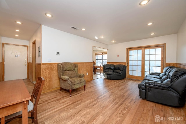 living room featuring wooden walls and light hardwood / wood-style flooring