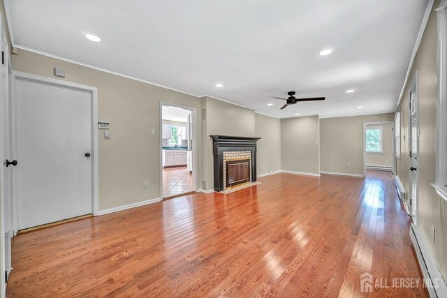 15 Federal Rd, Monroe, NJ 08831 - unfurnished living room with a baseboard radiator, plenty of natural light, a ceiling fan, ornamental molding, and light wood-type flooring