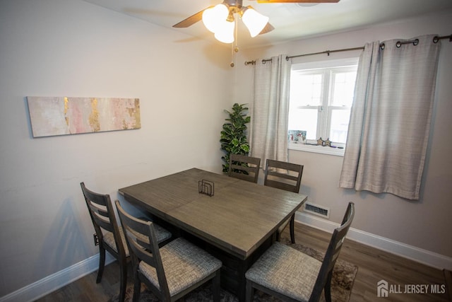 dining space featuring ceiling fan, visible vents, baseboards, and wood finished floors