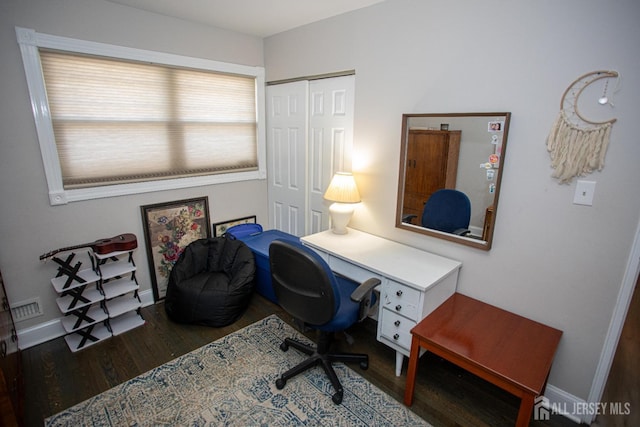 office area with wood finished floors, visible vents, and baseboards