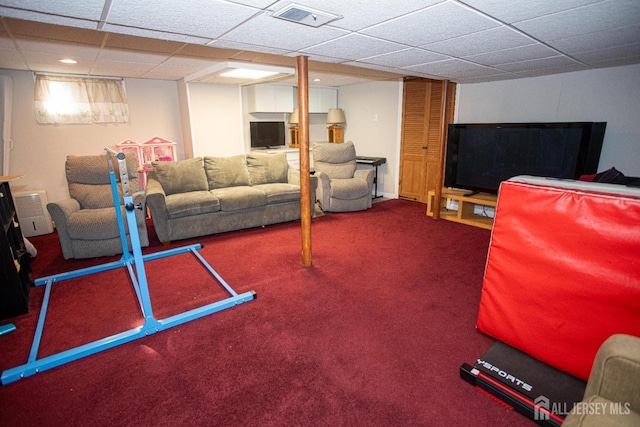 living area featuring visible vents, a paneled ceiling, and carpet flooring