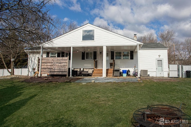 rear view of property featuring a lawn, entry steps, central AC, fence, and a chimney