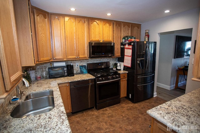 kitchen with range with gas stovetop, a sink, black fridge with ice dispenser, dishwasher, and stainless steel microwave