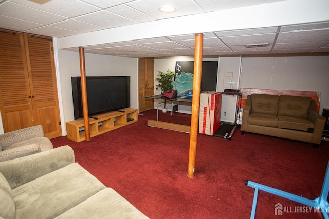 carpeted living room featuring a drop ceiling