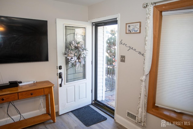 entryway with baseboards and wood finished floors