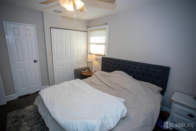 bedroom featuring a closet, baseboards, wood finished floors, and a ceiling fan