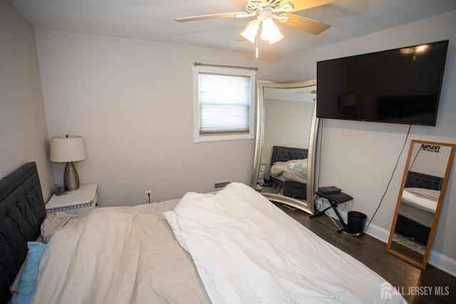 bedroom with visible vents, a ceiling fan, wood finished floors, a closet, and baseboards