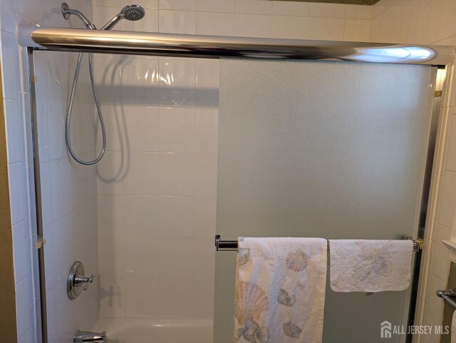 bathroom with combined bath / shower with glass door