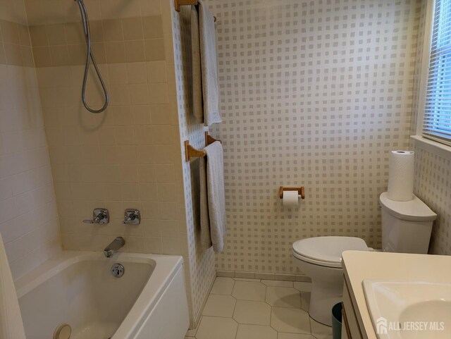 full bathroom with tile patterned flooring, sink, tiled shower / bath combo, and toilet