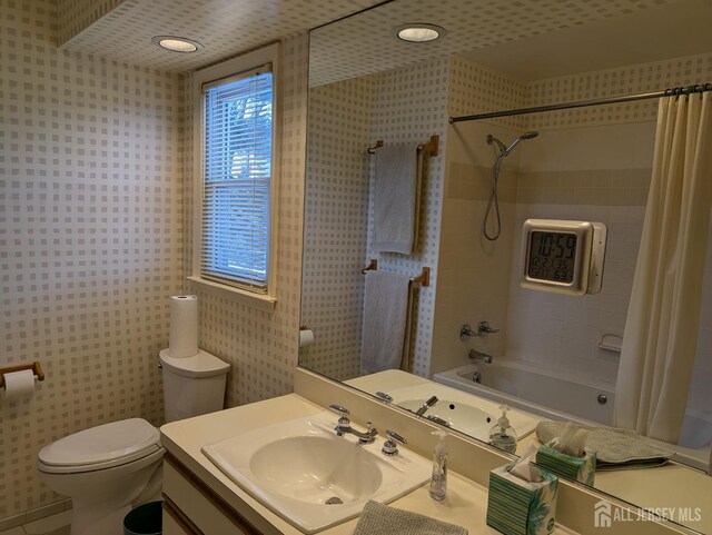 full bathroom with shower / bathtub combination with curtain, vanity, and toilet