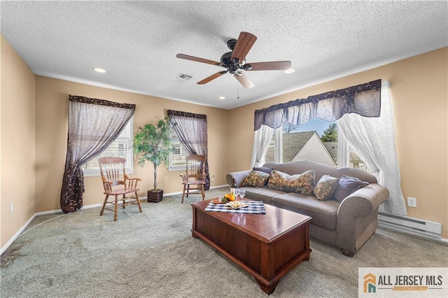 living area with a baseboard radiator, healthy amount of natural light, a ceiling fan, light colored carpet, and a textured ceiling