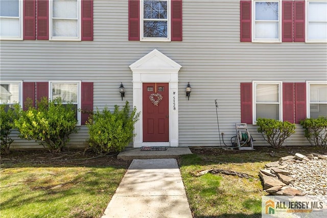 view of exterior entry with a yard