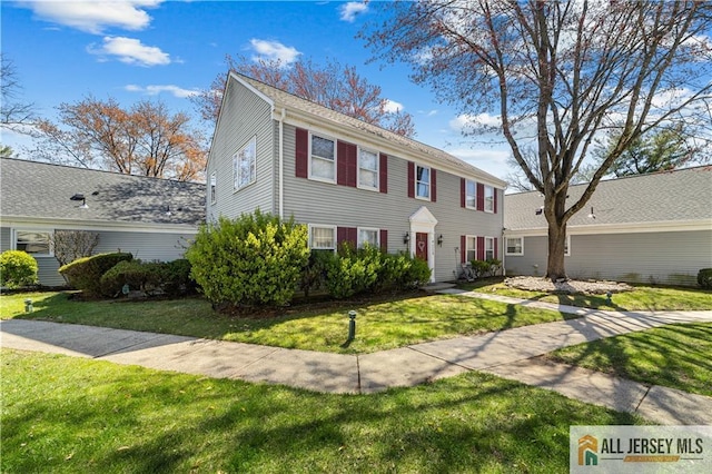 colonial home featuring a front yard