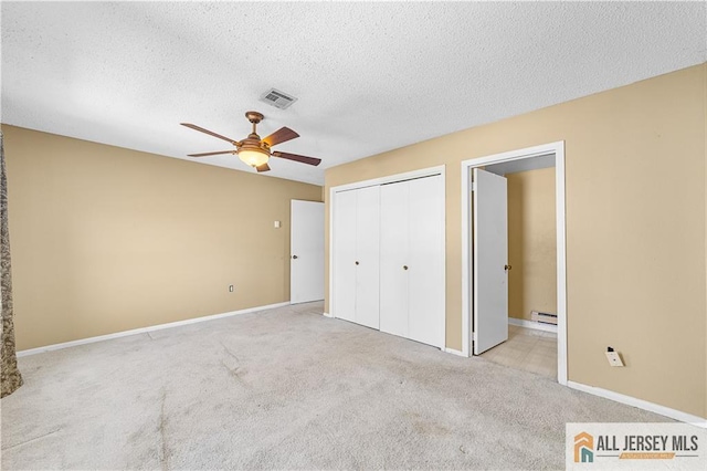 unfurnished bedroom with a baseboard radiator, carpet flooring, a textured ceiling, a closet, and baseboards