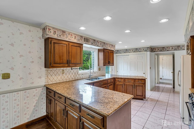 21 Shadyside Ct, Branchburg, NJ 08876 - kitchen with a peninsula, crown molding, recessed lighting, brown cabinetry, and light stone counters
