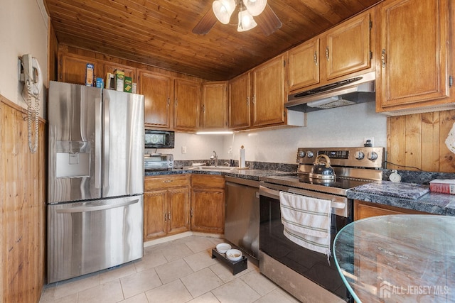 58 Hudson St, Menlo Park Terrace, NJ 08840 - kitchen featuring stainless steel appliances, under cabinet range hood, dark countertops, light tile patterned floors, and brown cabinets