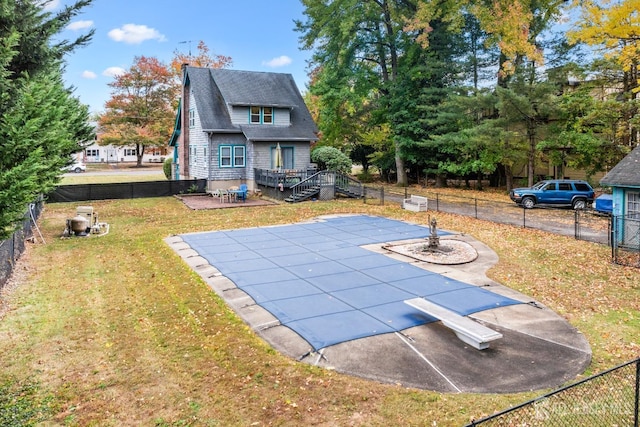 view of pool featuring a deck, a yard, a diving board, and a patio