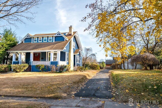 view of front of home with a porch and a front yard