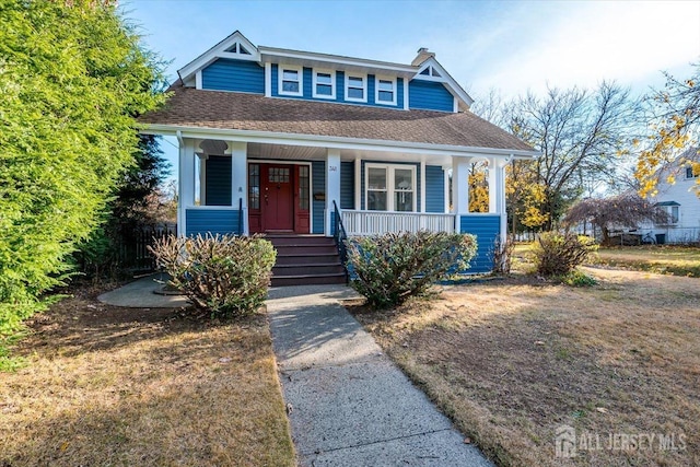 bungalow-style home featuring covered porch and roof with shingles