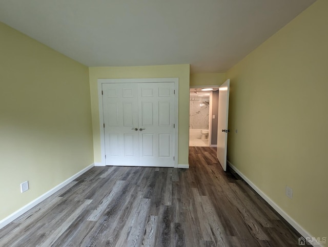 unfurnished bedroom featuring dark wood-type flooring and a closet