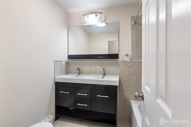 full bath featuring a baseboard radiator, double vanity, a sink, tile patterned flooring, and decorative backsplash