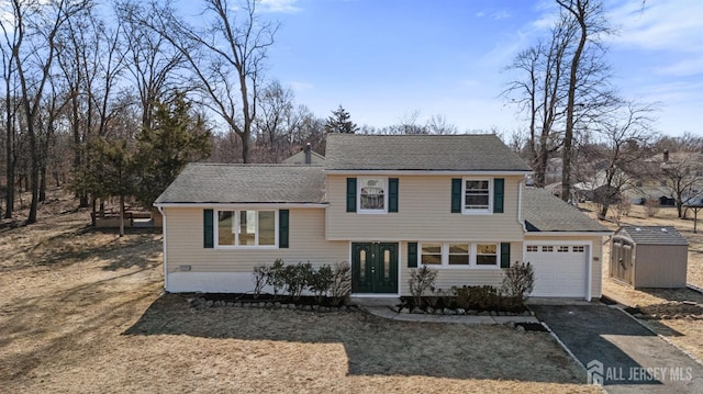 split level home with driveway, an attached garage, and roof with shingles