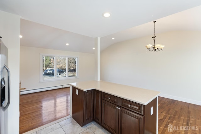 kitchen with a chandelier, baseboard heating, light countertops, and lofted ceiling