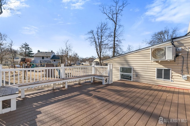 wooden terrace with a playground and ac unit