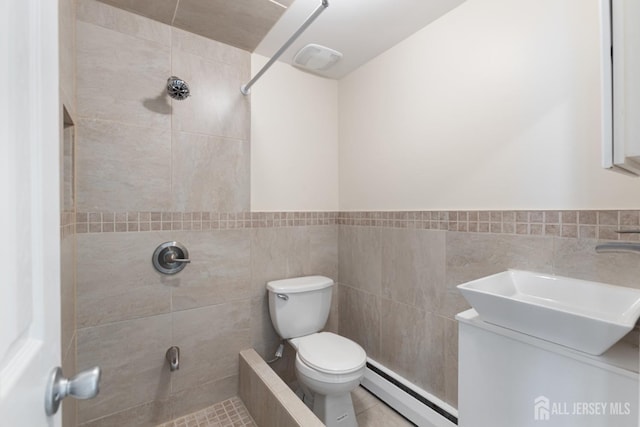 full bathroom with a sink, toilet, tiled shower, and a baseboard radiator