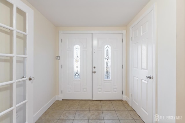 entryway featuring light tile patterned flooring and baseboards