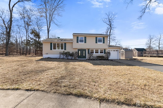 tri-level home featuring driveway, a front yard, and a garage