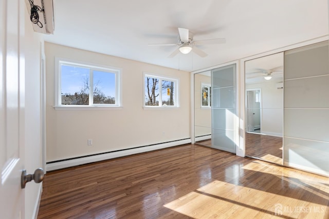 unfurnished bedroom with two closets, wood finished floors, ceiling fan, and a baseboard radiator