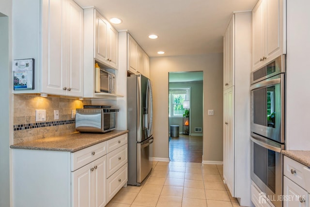 4 Wedgewood Ct, East Brunswick, NJ 08816 - kitchen with appliances with stainless steel finishes, white cabinetry, tasteful backsplash, light tile patterned floors, and baseboards