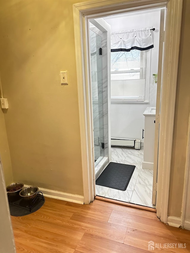 7 Hazelhurst St, New Brunswick, NJ 08901 - bathroom featuring baseboard heating, a shower stall, baseboards, and marble look tile flooring