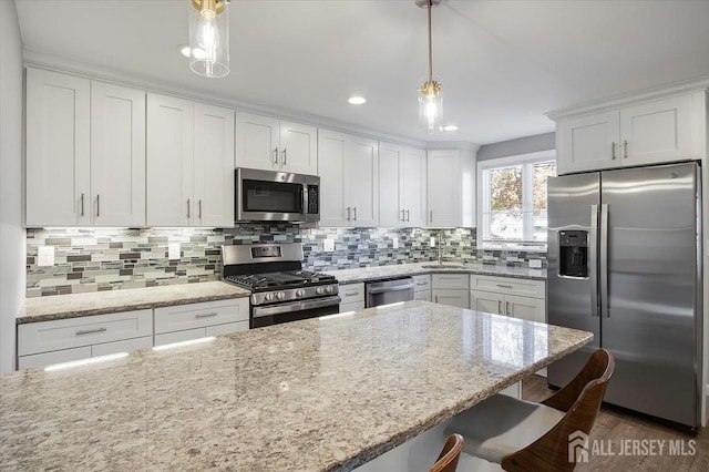 15 Douglas St, Sayreville, NJ 08872 - kitchen featuring appliances with stainless steel finishes, a sink, white cabinetry, a breakfast bar area, and decorative backsplash