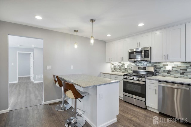 15 Douglas St, Sayreville, NJ 08872 - kitchen with appliances with stainless steel finishes, backsplash, dark wood finished floors, light stone countertops, and recessed lighting