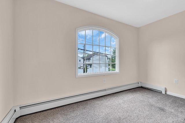 empty room featuring carpet, baseboards, and baseboard heating