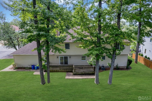 back of property featuring a deck, a yard, and fence