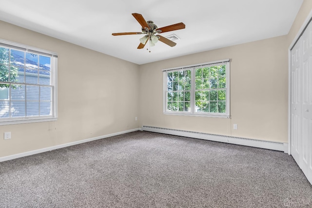 carpeted spare room featuring a baseboard heating unit, visible vents, baseboards, and a ceiling fan